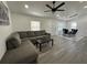 Open-concept view of the living room with gray sectional, ceiling fan, table and into dining area at 1913 Park Ave, Tarpon Springs, FL 34689