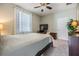 Comfortable bedroom with natural light and neutral walls, featuring a large window, closet, dresser, and wall-mounted TV at 19445 Redwood Point Dr, Tampa, FL 33647