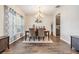Elegant dining room featuring a chandelier, wood-look flooring, and decoratively adorned walls at 19445 Redwood Point Dr, Tampa, FL 33647