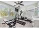 Bright home gym featuring an elliptical, treadmill, weight bench, and natural light from multiple windows at 19445 Redwood Point Dr, Tampa, FL 33647