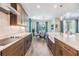 Modern kitchen featuring wood cabinets, stone countertops, stainless appliances, and an adjacent dining area with lots of light at 19445 Redwood Point Dr, Tampa, FL 33647