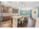 Open concept kitchen with stainless appliances, stone countertops, pendant lights, wood look tile, and adjacent breakfast nook at 19445 Redwood Point Dr, Tampa, FL 33647