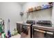 Well-equipped laundry room featuring modern washer, dryer, utility sink, and overhead storage shelving at 19445 Redwood Point Dr, Tampa, FL 33647