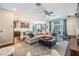 Open concept living room and kitchen area with a ceiling fan, a large sectional sofa, and wood-look tile flooring at 19445 Redwood Point Dr, Tampa, FL 33647