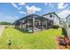 Beautiful backyard with screened in pool, lounge chairs, and well-maintained lawn and landscaping at 19445 Redwood Point Dr, Tampa, FL 33647