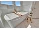 Close-up of a soaking tub featuring a faucet, stool and marble tile at 20 Bellevue Dr, Treasure Island, FL 33706