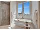 Elegant bathroom with a soaking tub, shower, and natural light at 20 Bellevue Dr, Treasure Island, FL 33706