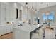 Stunning, modern white kitchen featuring an expansive island, stainless steel appliances, and stylish pendant lighting at 20 Bellevue Dr, Treasure Island, FL 33706