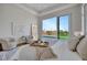 Beautiful main bedroom featuring waterfront view, tray ceiling, sitting area, and sliding glass doors at 20 Bellevue Dr, Treasure Island, FL 33706