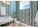 Chic powder room with designer wallpaper and elegant fixtures at 20 Bellevue Dr, Treasure Island, FL 33706