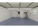 A wide-angle shot of the garage, featuring a gray epoxy floor, white walls, storage cabinets and utility connections at 2008 41St W St, Bradenton, FL 34205