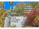 View of the condo building with lush landscaping and a vibrant red flowering bush in front at 201 W Laurel St # 212, Tampa, FL 33602