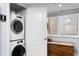 A bright laundry room featuring stacked washer/dryer and natural light from the window at 201 W Laurel St # 212, Tampa, FL 33602