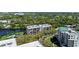 Expansive view showcasing contemporary condos nestled among lush greenery and a tranquil lake at 220 Belleview Blvd # 209, Belleair, FL 33756