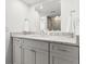 Bathroom vanity featuring gray cabinets, chrome hardware, and a speckled granite countertop with a large mirror at 220 Belleview Blvd # 209, Belleair, FL 33756