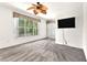 Bright bedroom features neutral carpeting, ceiling fan, and a large window with peaceful outdoor views at 2206 Preservation Dr # 2206, Plant City, FL 33566