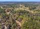 Aerial view of a secluded property with a long driveway winding through lush greenery and mature trees at 22295 Powell Rd, Brooksville, FL 34602