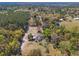 Aerial view showcasing a rural property featuring a home, outbuildings, and mature trees at 22295 Powell Rd, Brooksville, FL 34602