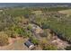 An aerial view shows a home surrounded by lush trees and pasture land at 22295 Powell Rd, Brooksville, FL 34602