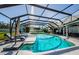 The screened-in pool with jacuzzi is surrounded by seating and lush landscaping at 2657 Crystal Circle Cir, Dunedin, FL 34698