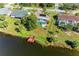 Aerial view of a lakeside home with a private dock and screened in pool with solar panels on the roof at 3381 Conway Blvd, Port Charlotte, FL 33952