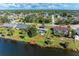 Aerial view of a lakeside home with a private dock and screened in pool with solar panels on the roof at 3381 Conway Blvd, Port Charlotte, FL 33952