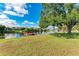 Picture-perfect backyard featuring a tranquil pond with a wooden dock, all set beneath a clear blue sky at 3381 Conway Blvd, Port Charlotte, FL 33952