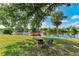 Enjoy your outdoor space with a pond view, a wooden dock, a cozy fire pit, and comfortable seating under shady trees at 3381 Conway Blvd, Port Charlotte, FL 33952