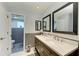 Bathroom featuring a double sink vanity with elegant mirrors and a connected toilet room at 3381 Conway Blvd, Port Charlotte, FL 33952
