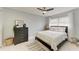 Bedroom with a neutral palette, ceiling fan, dresser, and a comfortably styled bed with a striped throw at 3381 Conway Blvd, Port Charlotte, FL 33952