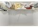 Walk-in closet with wire shelving stocked with pillows, linens, and some hanging clothes; tidy storage space at 3381 Conway Blvd, Port Charlotte, FL 33952