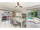 Elegant dining room with white floors, modern ceiling fan, and access to outdoor pool and patio at 3381 Conway Blvd, Port Charlotte, FL 33952