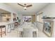 Bright dining area with white wood floors, modern ceiling fan, and seamless access to the kitchen at 3381 Conway Blvd, Port Charlotte, FL 33952