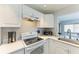 Well-lit kitchen features white cabinets and modern countertops at 3381 Conway Blvd, Port Charlotte, FL 33952