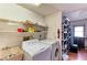 Practical laundry room featuring a utility sink, washer, dryer, and shelving for storage solutions at 3381 Conway Blvd, Port Charlotte, FL 33952
