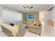 Cozy living room featuring a modern ceiling fan and warm, inviting furniture at 3381 Conway Blvd, Port Charlotte, FL 33952