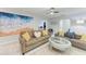 Cozy living room featuring comfortable couches, bright artwork, and plenty of natural light at 3381 Conway Blvd, Port Charlotte, FL 33952
