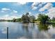 A scenic pond with trees and a dock reflected in the water, creating a serene and inviting view at 3381 Conway Blvd, Port Charlotte, FL 33952
