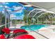 Inviting screened pool area, featuring lounge chairs and a clear view of the sky and surrounding landscape at 3381 Conway Blvd, Port Charlotte, FL 33952