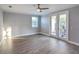 Bedroom with hardwood flooring, ceiling fan, neutral paint, white baseboards, and french doors to patio at 3553 Secluded Ct, Sarasota, FL 34240