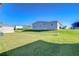 Spacious backyard with lush green grass and neighboring homes, offering a serene outdoor setting at 37530 Corey Lewis Ave, Zephyrhills, FL 33541