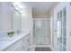 Bathroom featuring a double vanity with quartz countertop and a glass-enclosed shower and door to outside at 37530 Corey Lewis Ave, Zephyrhills, FL 33541