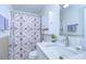 Bright bathroom featuring a single sink vanity, storage cabinet and patterned shower curtain at 37530 Corey Lewis Ave, Zephyrhills, FL 33541