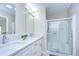 Bathroom featuring a double vanity with quartz countertop and a glass-enclosed shower at 37530 Corey Lewis Ave, Zephyrhills, FL 33541