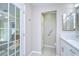 Bathroom featuring a single vanity with quartz countertop and a large storage cabinet and door to outside at 37530 Corey Lewis Ave, Zephyrhills, FL 33541