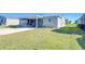 Exterior view with green lawn, carport, and screened porch, complemented by tidy landscaping at 37530 Corey Lewis Ave, Zephyrhills, FL 33541