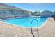 Community pool with lounge chairs, brick pavers, and pool ladder at 37530 Corey Lewis Ave, Zephyrhills, FL 33541