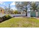 Spacious backyard area with green grass, a white fence, and a one-car garage at 4750 Burlington N Ave, St Petersburg, FL 33713