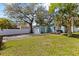 Charming home featuring a lush green lawn, mature trees, and a cozy outdoor patio at 4750 Burlington N Ave, St Petersburg, FL 33713