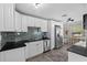 Well-lit kitchen with white cabinetry, black countertops, and stainless-steel appliances at 4750 Burlington N Ave, St Petersburg, FL 33713